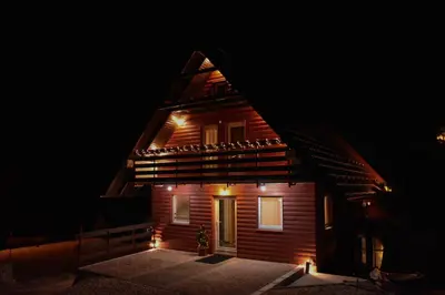 a house with lights on the front at night at Villa Šola in Kupres