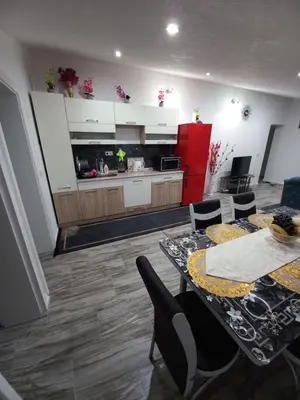 a kitchen with two tables and chairs and a red refrigerator at Apartman Varcar in Bihać