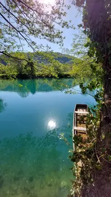 a boat sitting in the water next to a lake at Unatime.Krupa in Bosanska Krupa