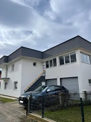 a black car parked in front of a white house at Apartman Marina stan na dan in Prijedor