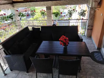 a black table and chairs with a black couch and flowers at Apartman Varcar in Bihać