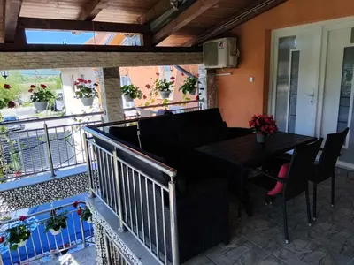 a patio with a table and chairs and a balcony at Apartman Varcar in Bihać
