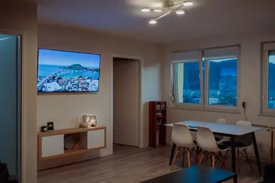 a living room with a table and chairs and a tv at 5 min Apartment in Banja Luka