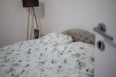 a bedroom with a bed with a floral bedspread at 5 min Apartment in Banja Luka