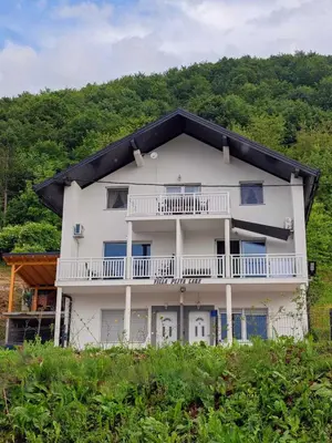a large white building with a black roof at Villa Pliva Lake in Jajce