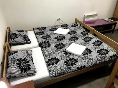 a bed with a black and white comforter on it at Kingdom Rooms Visoko in Visoko