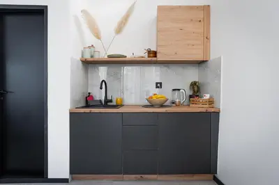 a kitchen with black cabinets and a counter at Urban city apartment in Visoko