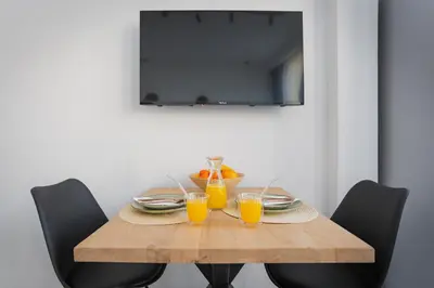 a wooden table with two glasses of orange juice at Urban city apartment in Visoko