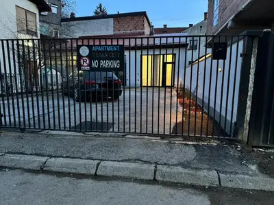 a gate with a no parking sign on it at Urban city apartment in Visoko