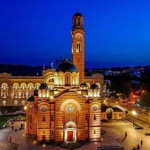 a large building with a clock tower at night at Bijeli Cvijet in Glamočani
