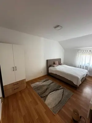 a white bedroom with a bed and a rug at Milincic‘s 2 Zimmerwohnung in Banja Luka