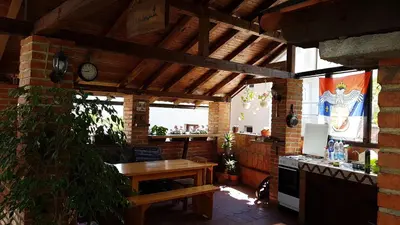 an outdoor kitchen with a table and a clock at Studio Apartman Ana Doboj in Doboj