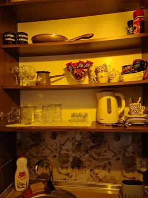 a kitchen shelf with dishes and utensils on it at Studio Apartman Ana Doboj in Doboj