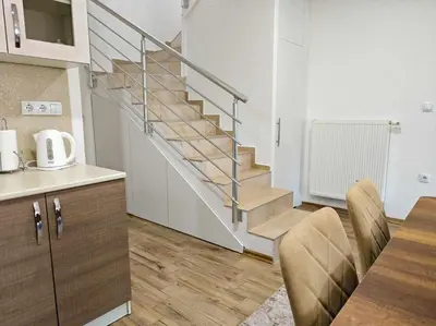 a kitchen with a staircase and a table with chairs at Villa Pliva Lake 2 in Jajce