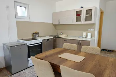 a kitchen with a wooden table with chairs around it at Villa Pliva Lake 2 in Jajce