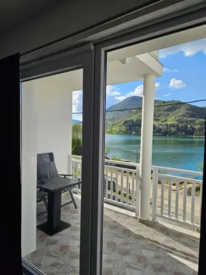 a balcony with a view of a lake and mountains at Villa Pliva Lake 2 in Jajce