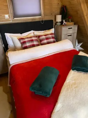 a large bed with a red blanket and pillows at Obiteljska oaza Vlašić in Vlasic