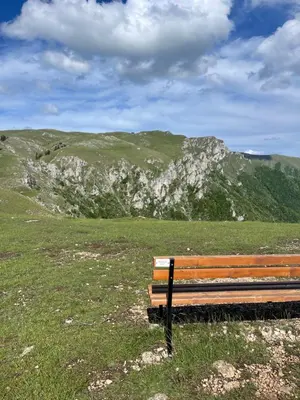 a bench in a field with mountains in the background at Obiteljska oaza Vlašić in Vlasic