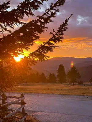 a sunset in the mountains with a wooden fence at Obiteljska oaza Vlašić in Vlasic