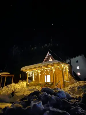 a cabin covered in lights in the snow at night at Obiteljska oaza Vlašić in Vlasic