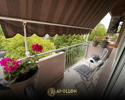 a balcony with flowers and a table and chairs at Stan na dan Apollon Doboj in Doboj
