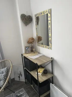 a mirror on a wall next to a shelf at Apartman Nej&Se Ravne in Visoko