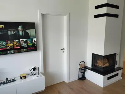 a living room with a fireplace and a tv on the wall at Apartman Nona in Kupres