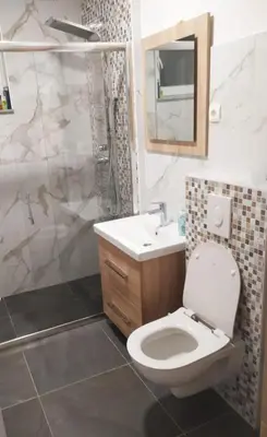 a bathroom with a toilet and a sink and a mirror at Apartman Nona in Kupres