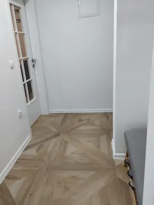 a hallway with a wooden floor and white walls at Apartman Nona in Kupres