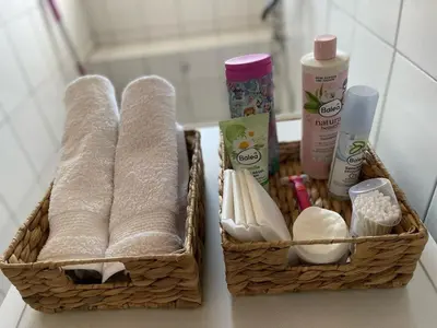 two baskets with towels and other products on a counter at Apartman Centar E&A in Tuzla