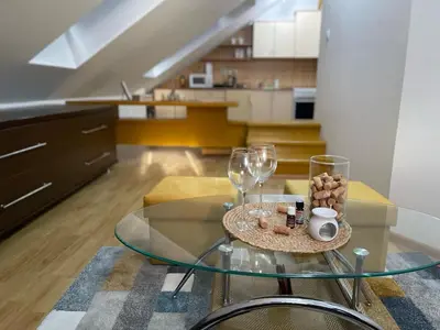 a living room with a glass table and wine glasses at Apartman Centar E&A in Tuzla