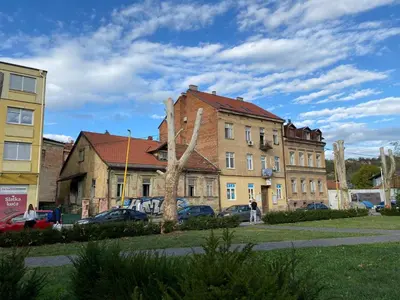 a group of buildings with cars parked in a parking lot at Apartman Centar E&A in Tuzla