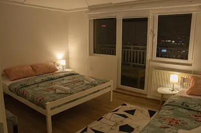 a bedroom with a bed and a window with a view at Apartment Forever in Tuzla
