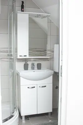 a white bathroom with a sink and a shower at Apartment Forever in Tuzla