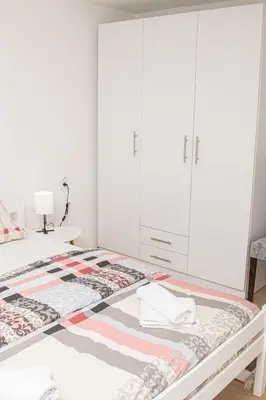 a bedroom with a bed with white cabinets at Apartment Forever in Tuzla