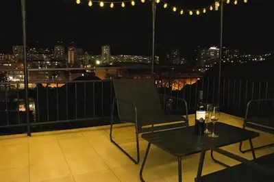 a table and chairs on a balcony at night at Apartment Forever in Tuzla