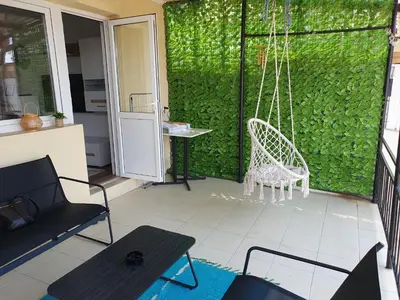 a porch with a swing and a chair at Apartment Forever in Tuzla