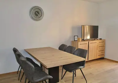 a wooden table and chairs in a room with a tv at Apartment Znaor in Kupres