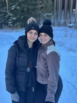 two young women standing next to each other in the snow at Apartment Znaor in Kupres