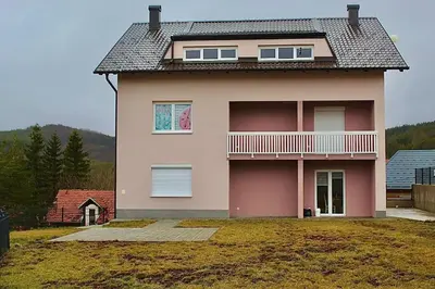 a house with a large yard in front of it at Apartment Znaor in Kupres