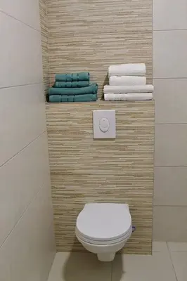a bathroom with a white toilet and towels at Apartment Znaor in Kupres
