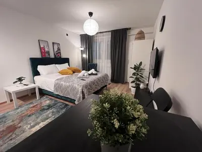 a bedroom with a bed and a table with plants at Apartman ROYAL Bulevar in Zenica