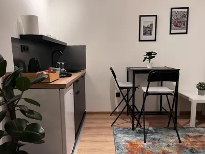 a kitchen with a counter and a table and chairs at Apartman ROYAL Bulevar in Zenica