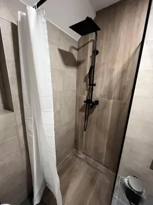a shower with a shower curtain in a bathroom at Apartman ROYAL Bulevar in Zenica