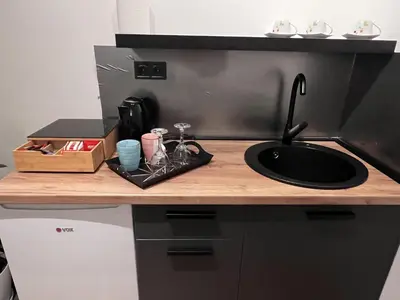 a kitchen counter with a sink on a counter top at Apartman ROYAL Bulevar in Zenica