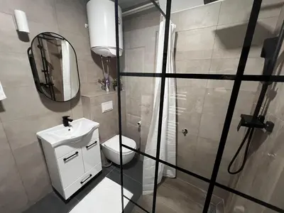 a bathroom with a shower and a toilet and a mirror at Apartman ROYAL Bulevar in Zenica