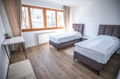 a bedroom with two beds and a window at E&A Apartman Ajla i Amir in Tuzla
