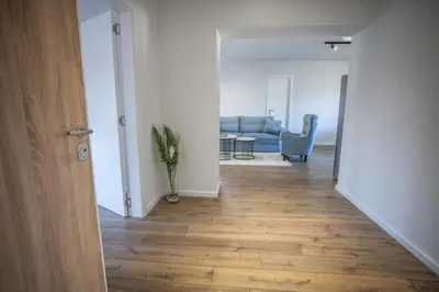 a hallway with a living room with a blue couch at E&A Apartman Ajla i Amir in Tuzla