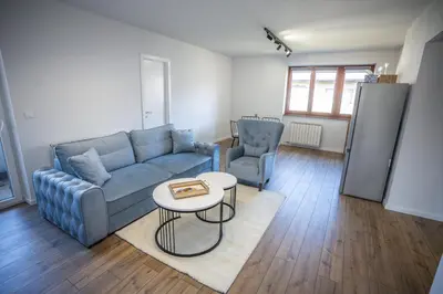 a living room with a blue couch and a table at E&A Apartman Ajla i Amir in Tuzla