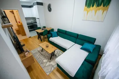 a living room with a green couch and a table at Apartman Mihalena in Banja Luka
